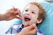 © rogerphoto - Close up of boy having his teeth examined by a dentist.