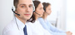 © rogerphoto - Call center operators. Focus at businessman in headset while consulting customers.