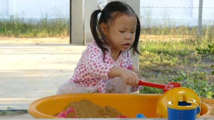 Wall Mural - Asian girl playing sand at home