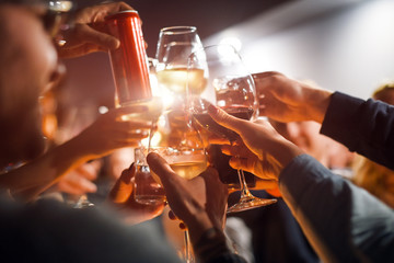 Wall Mural - Cheerful friends clinking glasses above dinner table. Alcohol and toasting, party and celebration theme. Congratulations on the event.