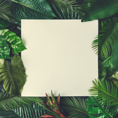 Wall Mural - Creative nature layout made of tropical leaves and flowers With paper card note. Flat lay. Summer concept.