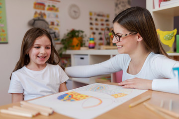 Wall Mural - Smiling mother and daughter enjoying quality time together learning