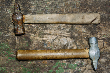 Rusty two hammers lie on old boards background with copy space for text, top view, flat lay, time concept