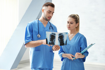 Poster - Doctor and medical assistant discussing x-ray image in office