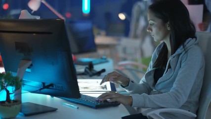  Young mixed ethnicity computer game design team working together in dark office. 