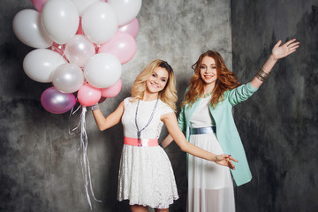 Blonde and redhead. Two young charming girlfriends at the party.