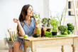© rh2010 - Beautiful woman sitting with healthy green food and drinks at home. Vegan meal and detox concept