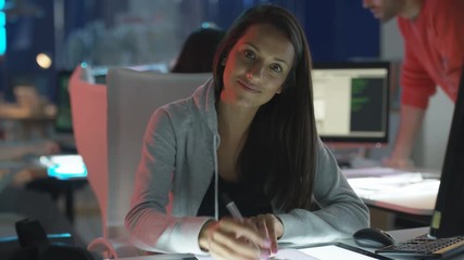  Portrait smiling young computer game designer drawing at her desk. 
