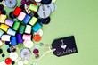 I love Sewing - with blackboard, colorful cotton thread reels and buttons on green cardboard background
