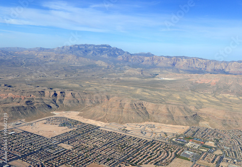 Plakat Rozwijająca się podmiejska i komercyjna zabudowa w Las Vegas w stanie Nevada podnosi się wraz z górami na zachodniej pustyni wraz ze wzrostem populacji