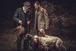 © Nejron Photo - Two hunters with dogs and shotguns in a traditional shooting clothing.