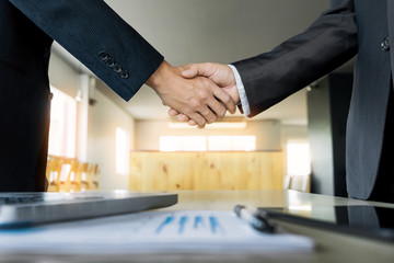 Two confident business man shaking hands during a meeting in the office, success, dealing, greeting and partner concept.