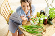 © rh2010 - Young and happy woman eating healthy salad sitting on the table with green fresh ingredients indoors