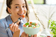 © rh2010 - Closeup of a woman eating healthy salad with tomatoes cherry indoors