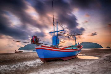 Wall Mural - Fishing boat, waves clouds and blue sky with sunrise, nature background.