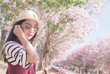 © sompong_tom - Women Asia Music Earphone tourist hat See pink trumpet tree and sky