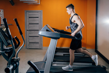 Wall Mural - Athletic man running on the treadmill