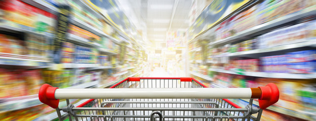 Supermarket aisle with empty red shopping cart