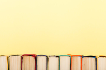 education and wisdom concept - books on wooden table, color background