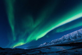 Fototapeta Tęcza - The polar Northern lights in the mountains of Svalbard, Longyearbyen, Spitsbergen, Norway wallpaper