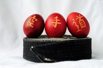 Painted Easter eggs with karate hieroglyphs up on a black belt for martial arts.