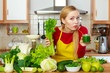 © Voyagerix - Woman in kitchen holding vegetable smoothie juice