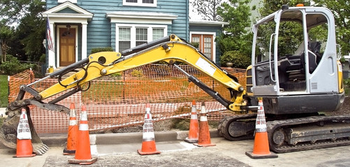 Residential neighborhood sidewalk and street repair maintenance machinery.