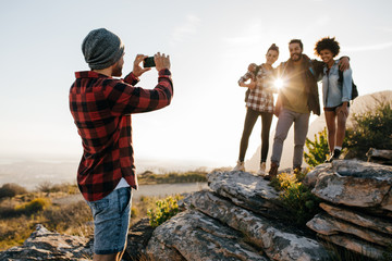 Wall Mural - friends on hike taking picture by smartphone