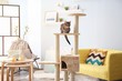 © Africa Studio - Cute cat sitting on tree in modern room