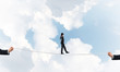 © adam121 - Business concept of risk support and assistance with man balancing on rope