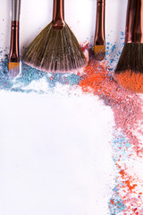 Poster - Makeup brushes with blush or eyeshadow of pink, blue and coral tones sprinkled on white background