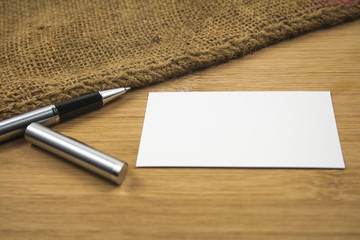 Pen and business card over the wooden board