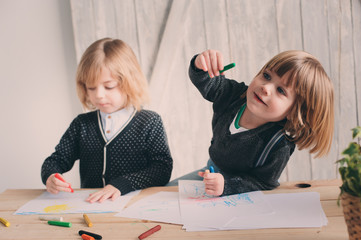 two kid brothers drawing together at home. happy siblings spending time together and playing.