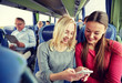 © Syda Productions - happy young women in travel bus with smartphone