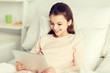 © Syda Productions - happy girl lying in bed with tablet pc at home