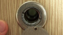 Close-up View Of Man Looking Through The Door Peephole. 4K