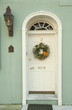 Curved arch and window over doorway with wreath in an urban home.