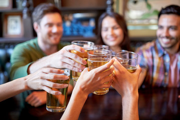 Wall Mural - happy friends drinking beer at bar or pub