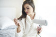 © gpointstudio - Close up of woman with hair dryer .