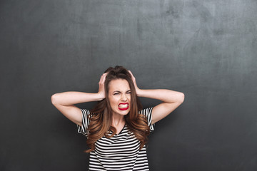 Canvas Print - Young Screaming woman covering her ears