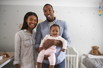 Wall Mural - Portrait Of Parents With Baby Daughter In Nursery