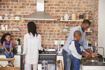 Wall Mural - Children Helping Parents To Prepare Meal In Kitchen