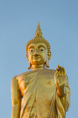 The standing buddha statue on blue sky, located in Chanthaburi, Thailand.