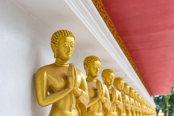 Golden Buddha Statue on the wall in public temple, Thailand.