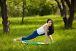 © olenachukhil - Young girl working out outdoors. Beautiful woman doing pilates, yoga and fitness exercices on nature.