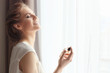 © Africa Studio - Beautiful young woman with bottle of perfume near window at home