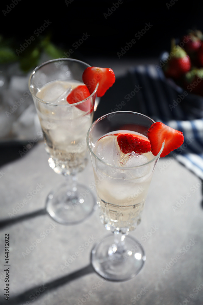 Refreshing cocktails with strawberry on gray table