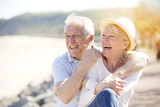 Fototapeta  - Senior couple relaxing by the sea on sunny day