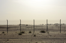 Fence In The Sand Desert At Sunny Day