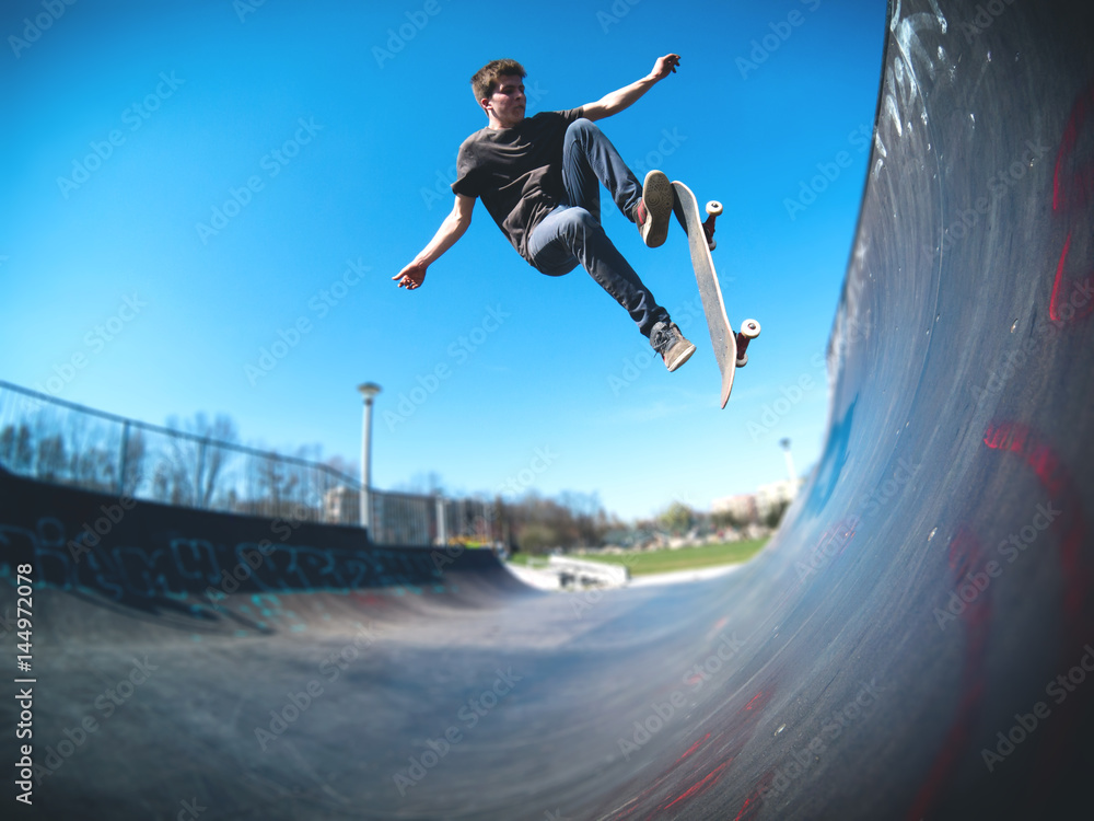 Skateboarder doing ollie on ramp - obrazy, fototapety, plakaty 